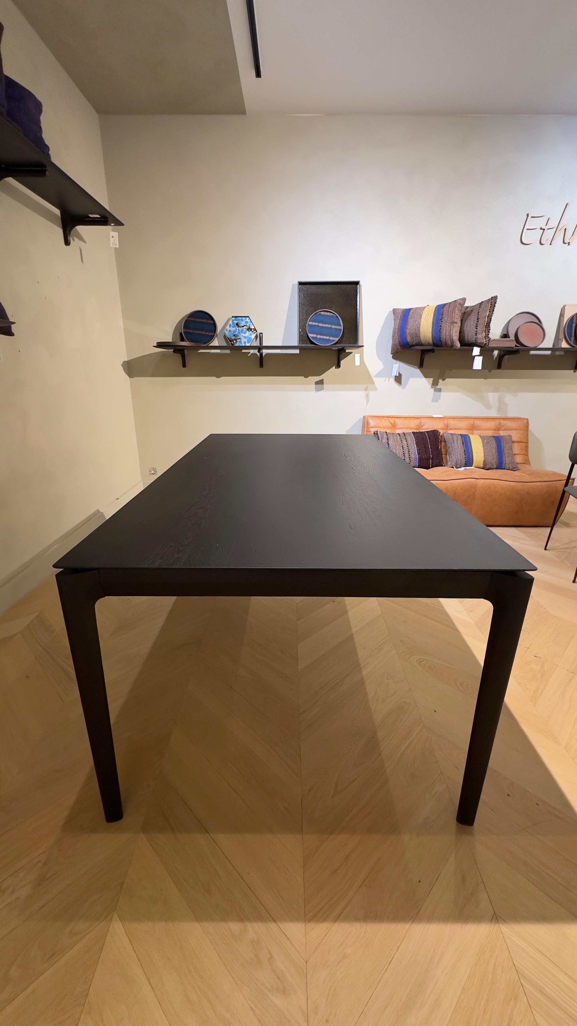 Ethnicraft BOK dining table made of black oak, with other furniture in the room