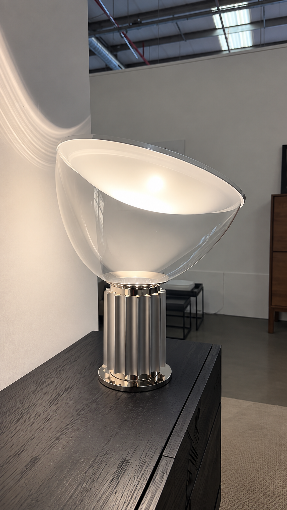 Lampe de table Flos TACCIA en aluminium argenté, exposée dans le showroom
