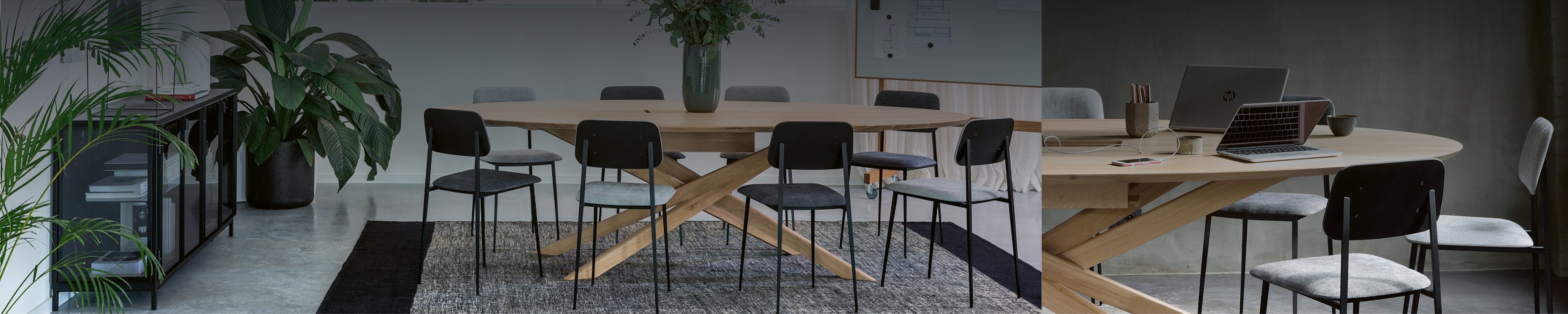 Design-Konferenztisch mit laptopfreundlicher Oberfläche, umgeben von gepolsterten Stühlen in einem stilvollen Raum mit Betonboden und rauer Wandstruktur.