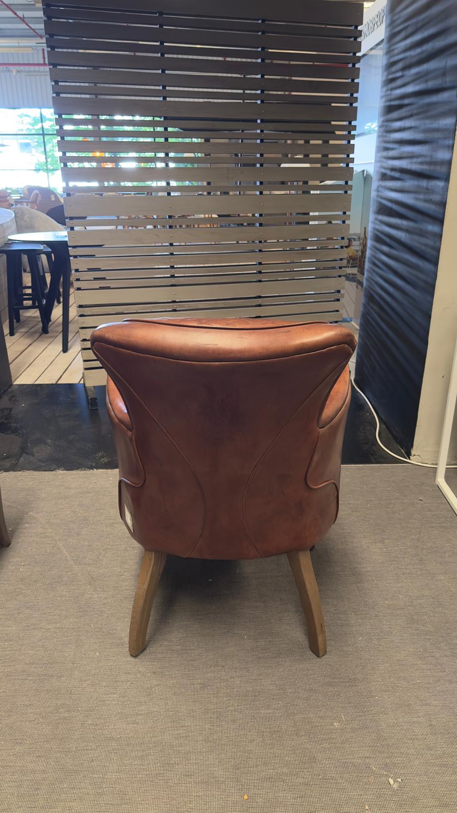 Chaise « SIDE SADDLE » en cuir de Timothy Oulton, exposée dans le showroom