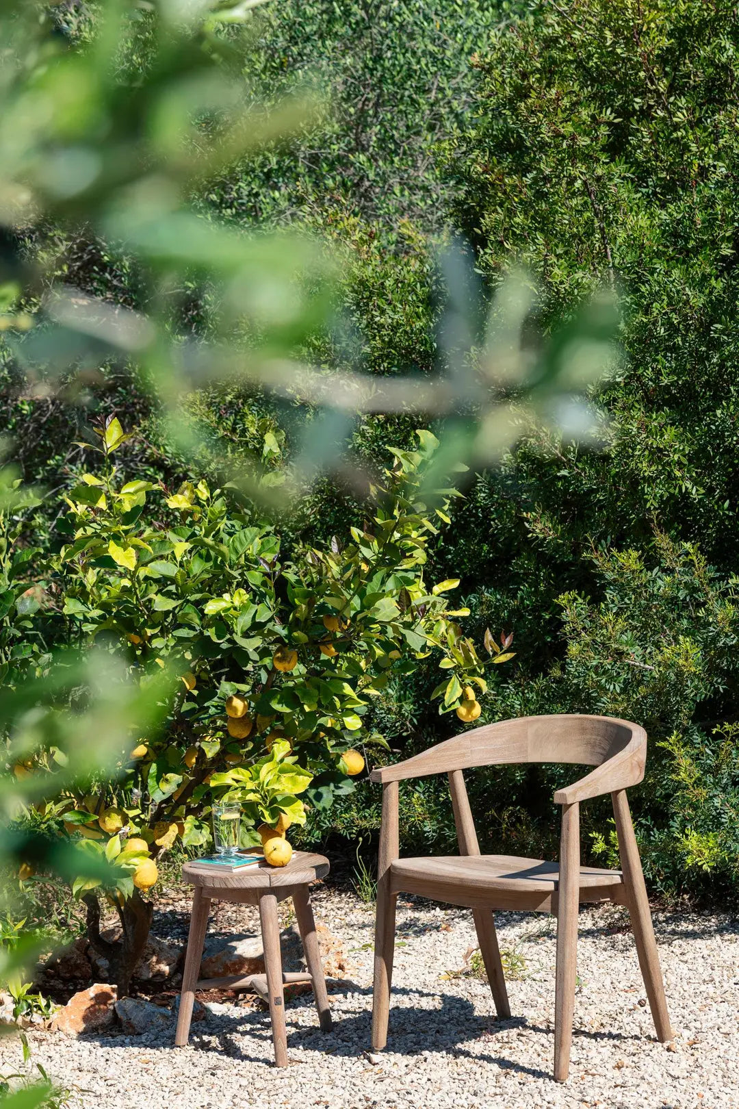 Tabouret en teck Asti de Gommaire dans une scène naturelle de jardin - sobre, robuste et intemporel comme siège ou table d'appoint