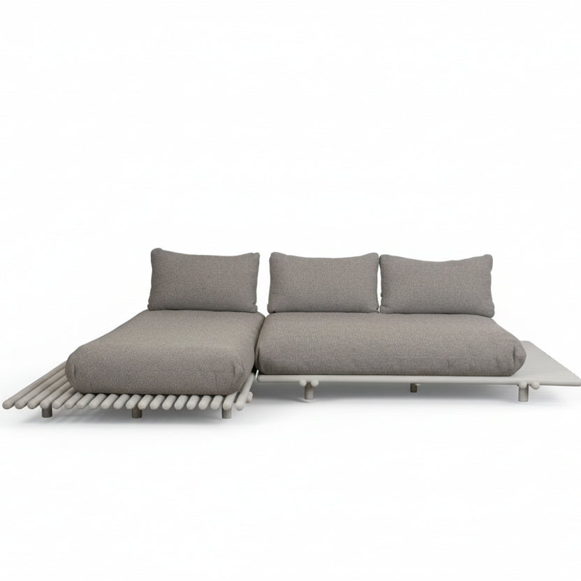 Cane-line STICKS Sofa mit Aluminiumgestell und hellbraunen Rise-Kissen – moderne Leichtigkeit trifft warme Textilstruktur