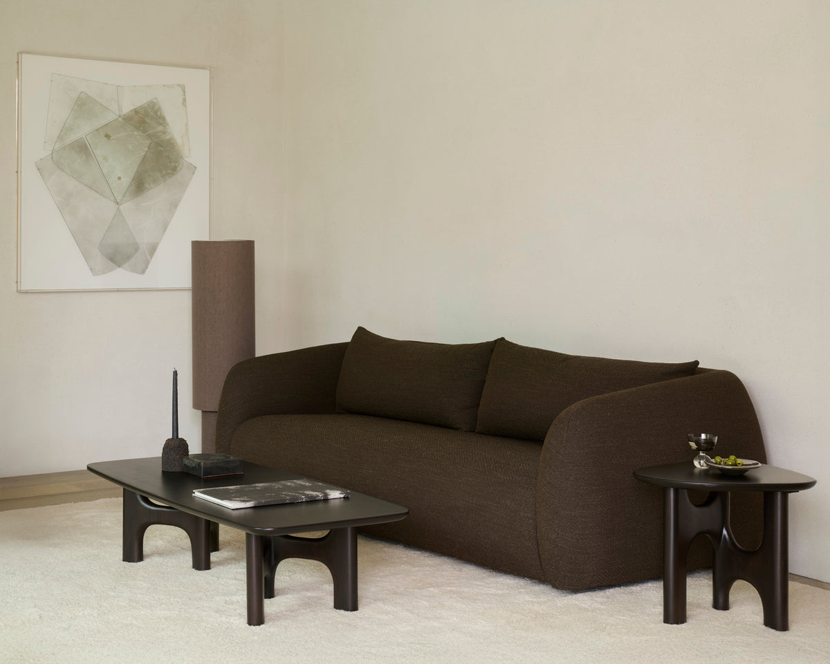 Table basse d'Ethnicraft FLOW en acajou, couleur Rose Brown, devant un canapé moderne dans un salon lumineux.