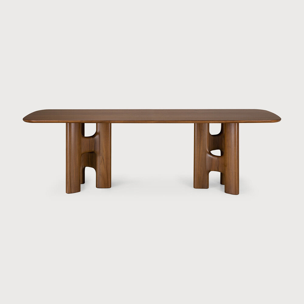 Ethnicraft FLOW solid wood dining table with a gently rounded tabletop and sculptural table legs, as seen from the front.