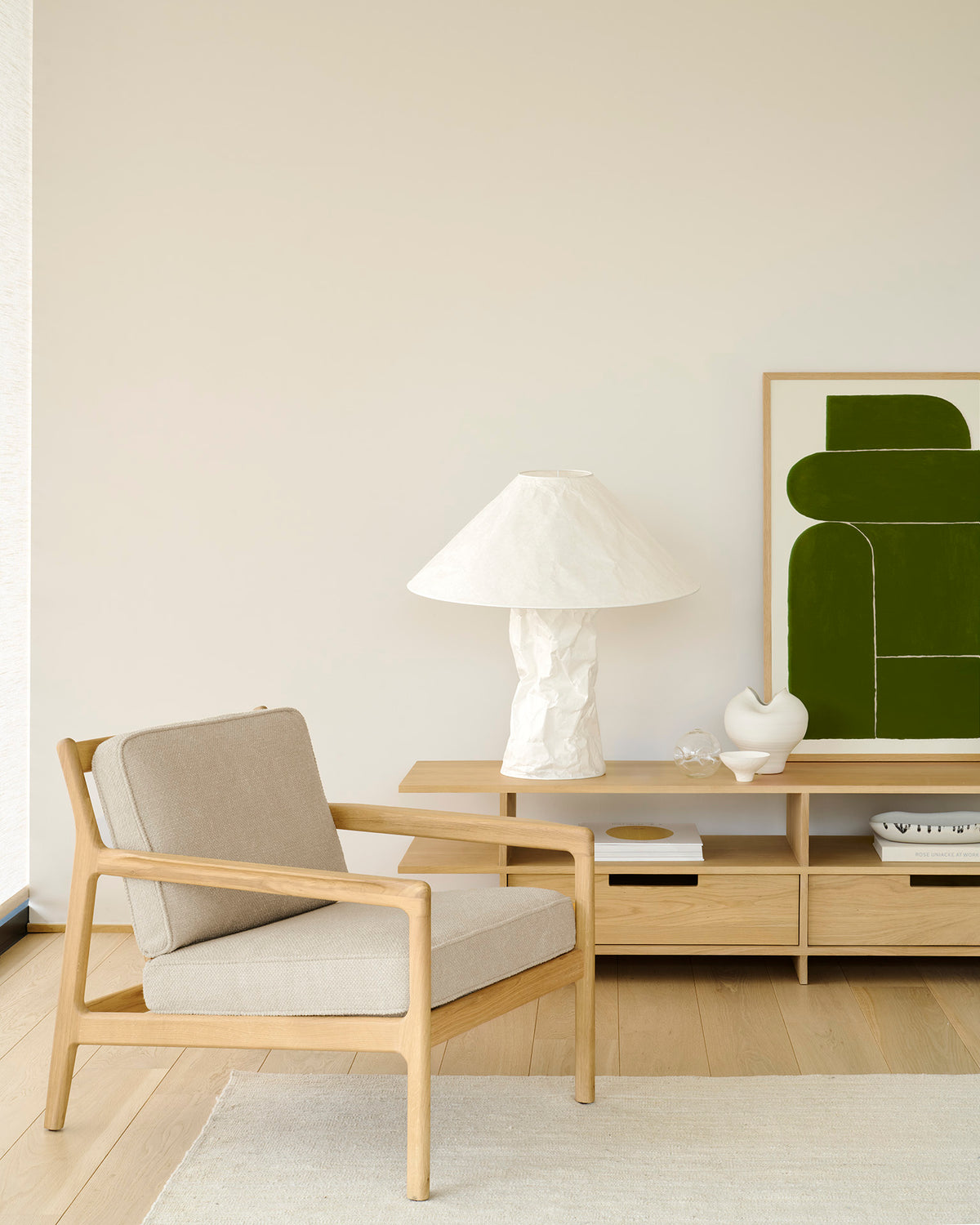 Ethnicraft JACK Loungesessel aus Eichenholz Natural mit Ivory Stoffkissen in einem modernen Wohnzimmer.