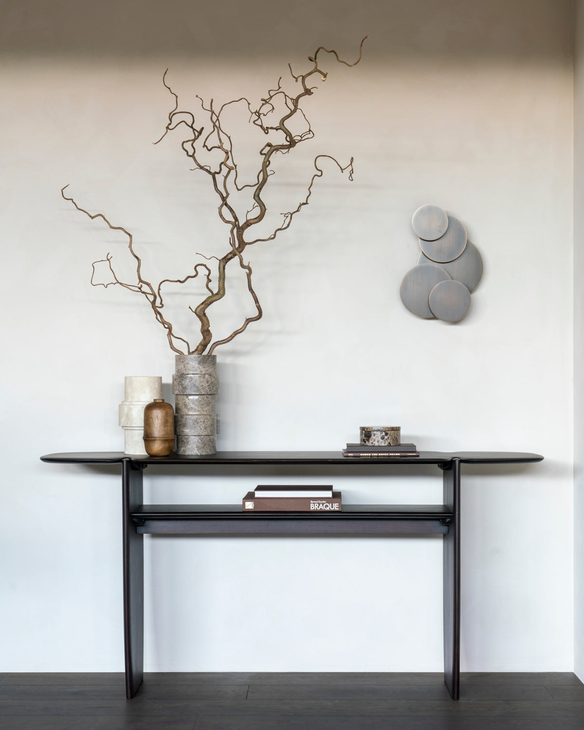 Console PI d'Ethnicraft 160 x 75 cm en acajou foncé, agrémentée d'objets décoratifs, dans une entrée lumineuse.