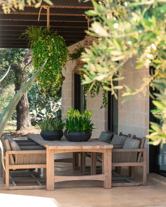 Table de jardin Jacoba au format Low-Dining - teck expressif dans une scène de jardin calme à l'atmosphère méditerranéenne