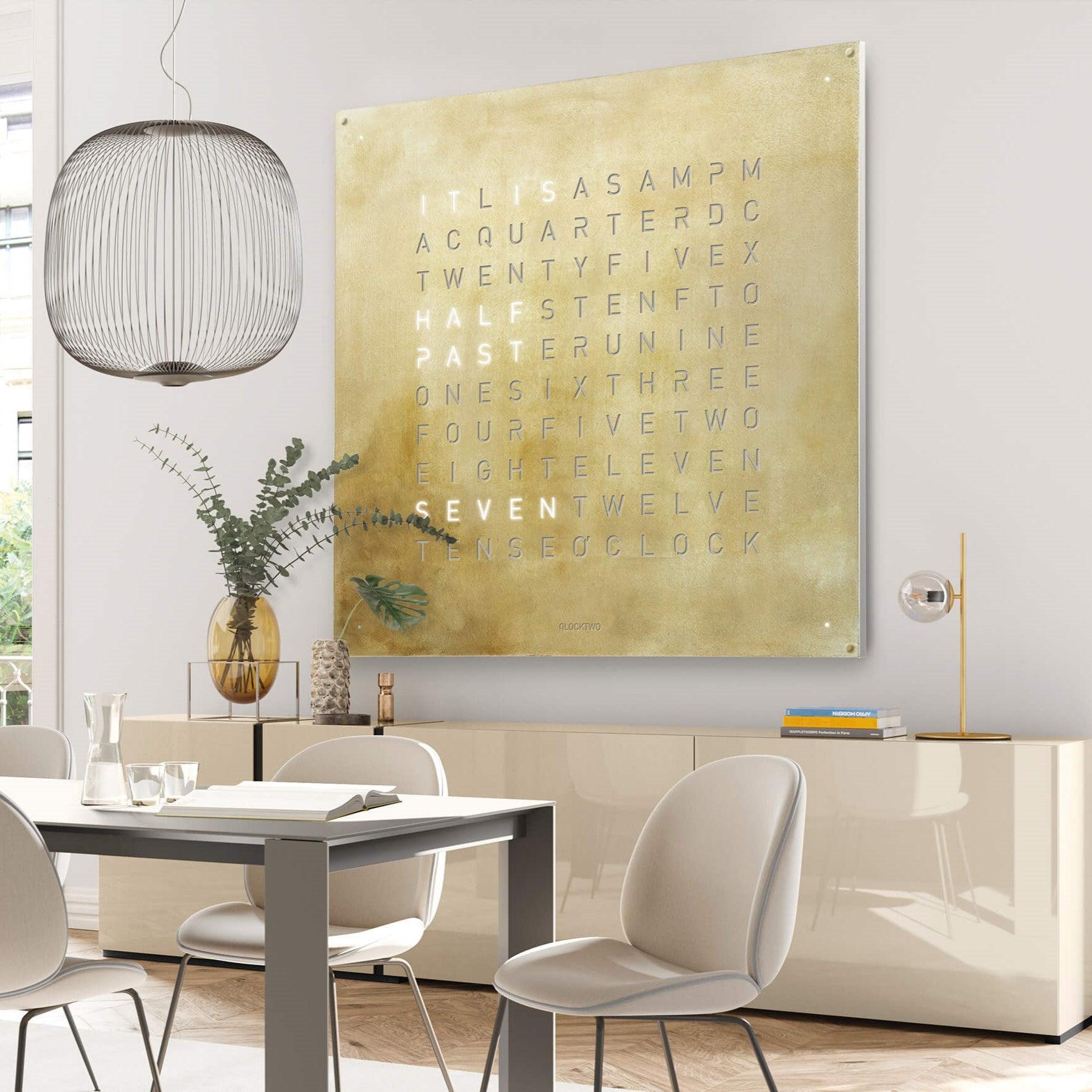 QLOCKTWO EARTH 180 SILVER & GOLD – exklusive Luxus-Wanduhr mit 180 cm Front aus gebürstetem Edelstahl und 24-Karat-Gold-Schriftbild. High-End Designuhr für moderne Architektur, Interior Design und Sammlerräume