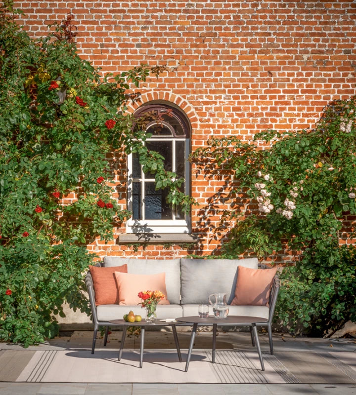 Vincent Sheppard LEO Couchtisch in Lava vor einem Gartensofa auf der Terrasse