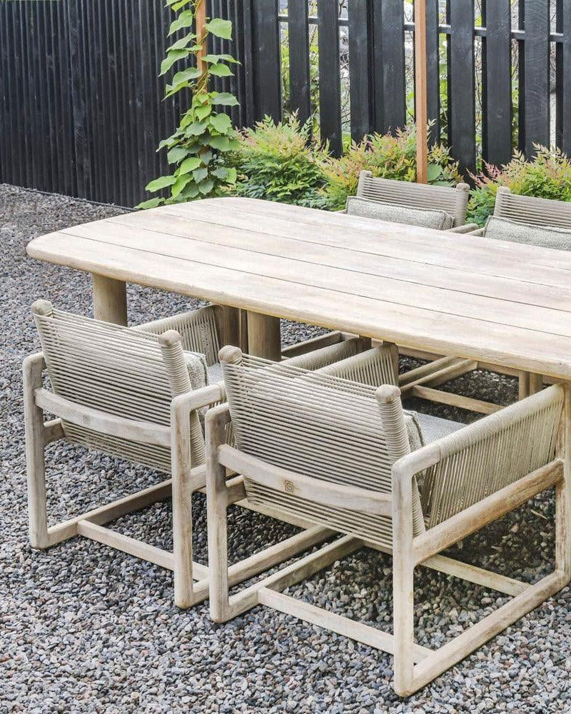 Table à manger CARLO dans le jardin sous Parasol - table généreuse en teck de Gommaire comme pièce maîtresse d'un groupe de repas Outdoor dans la verdure