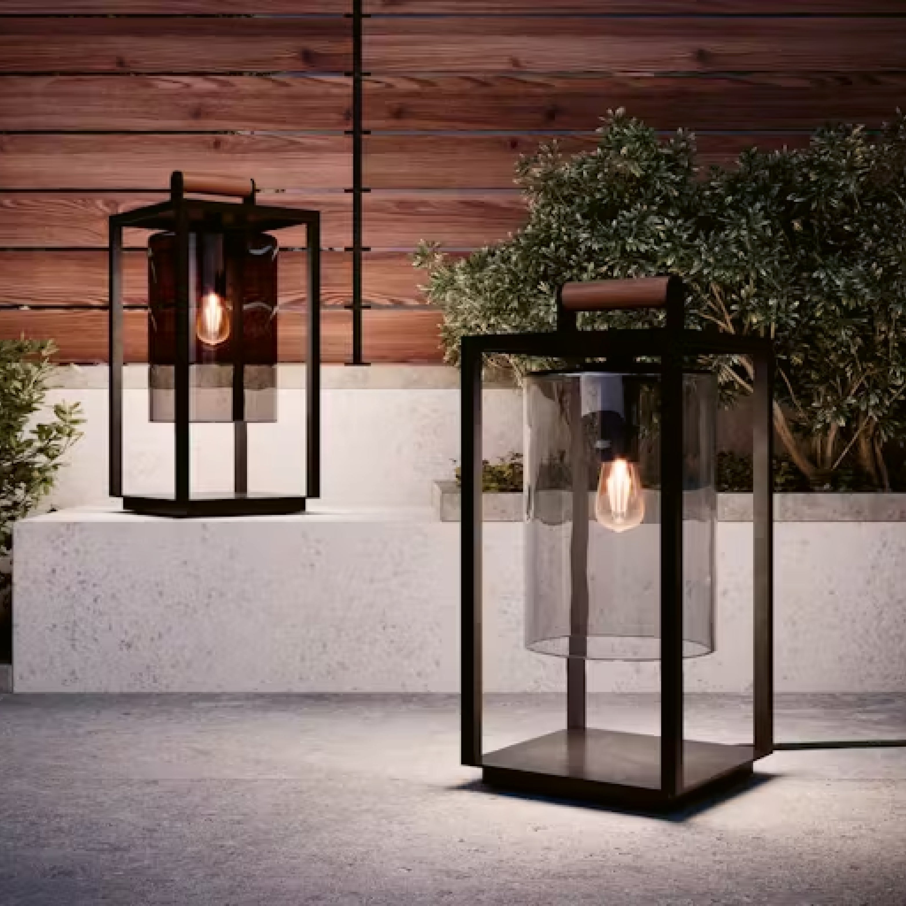 Zeitlose Outdoor-Laterne mit Glaszylinder und Metallrahmen auf einer Terrasse bei Dämmerlicht – Mobilversion.