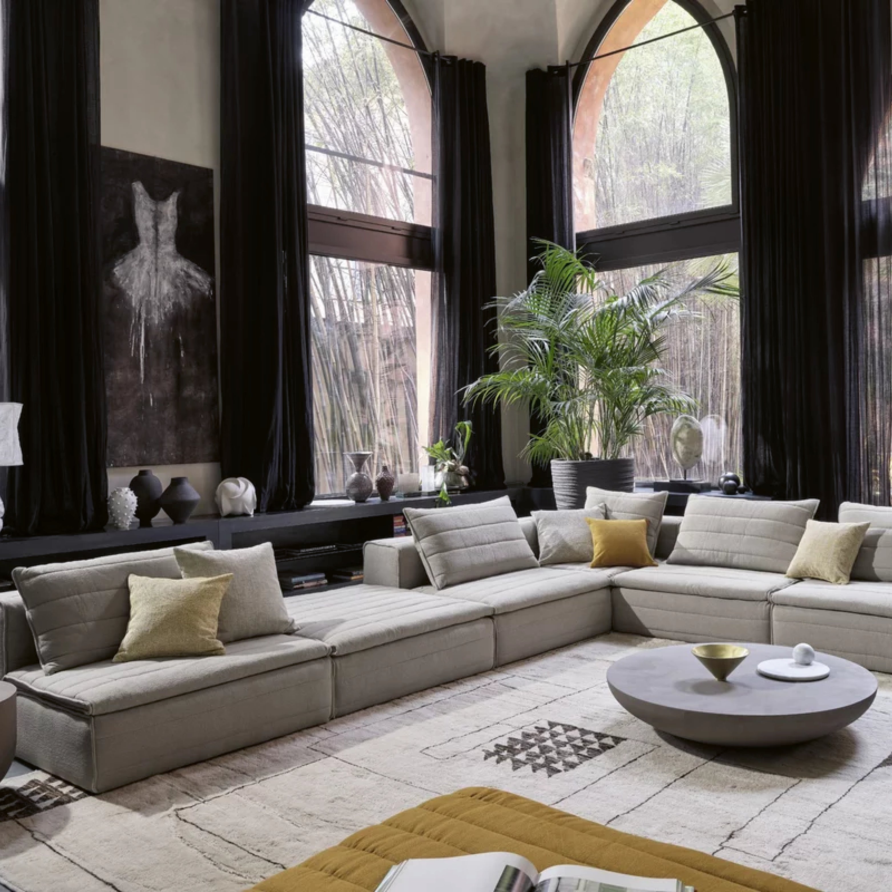 Modulares Designsofa in L-Form mit grauen Polstern und wechselbaren Kissen in modernem Wohnzimmer.