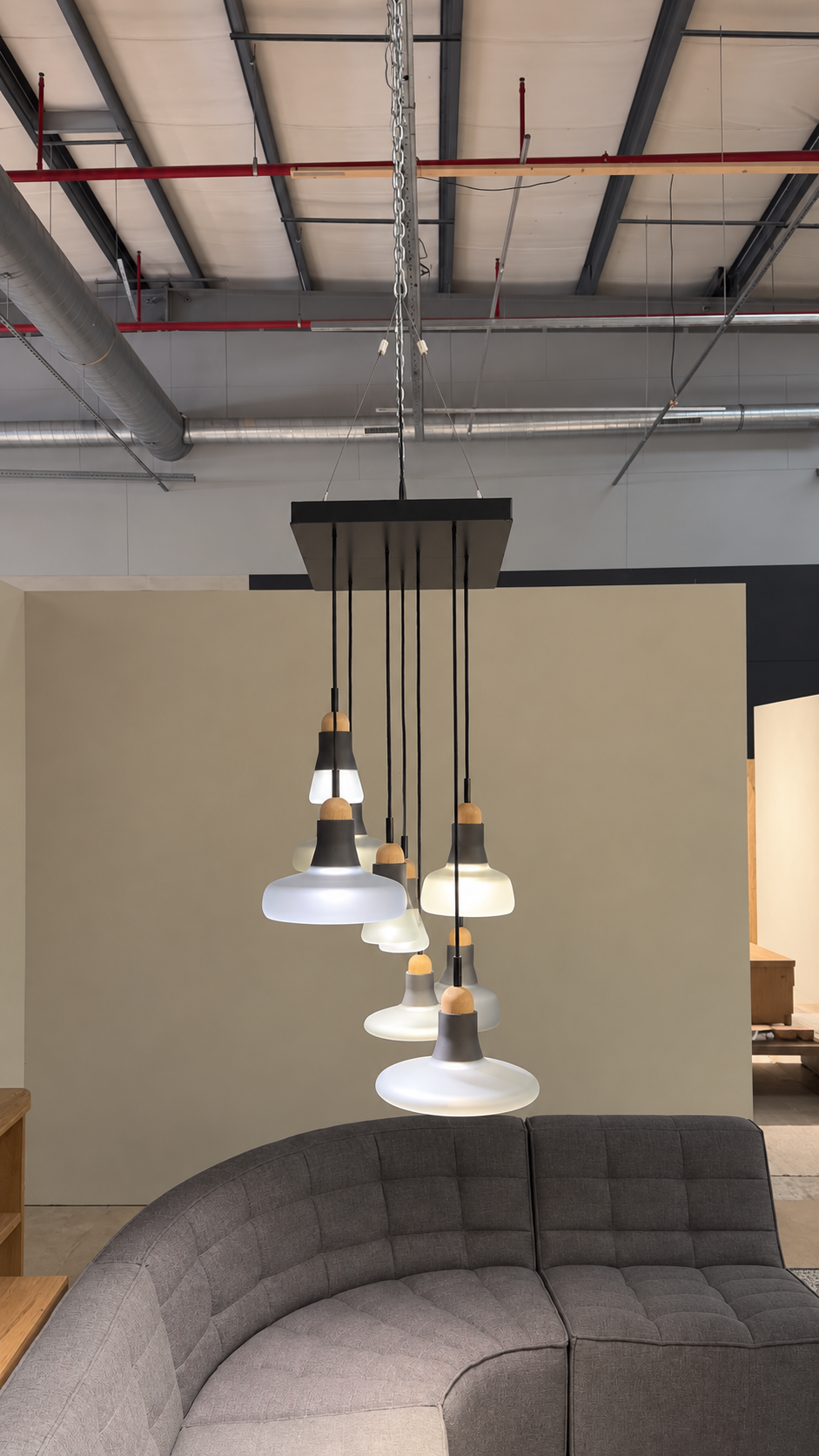 Suspension Brokis SHADOWS L, en Smoke Grey et Clear Oak, exposée dans le showroom