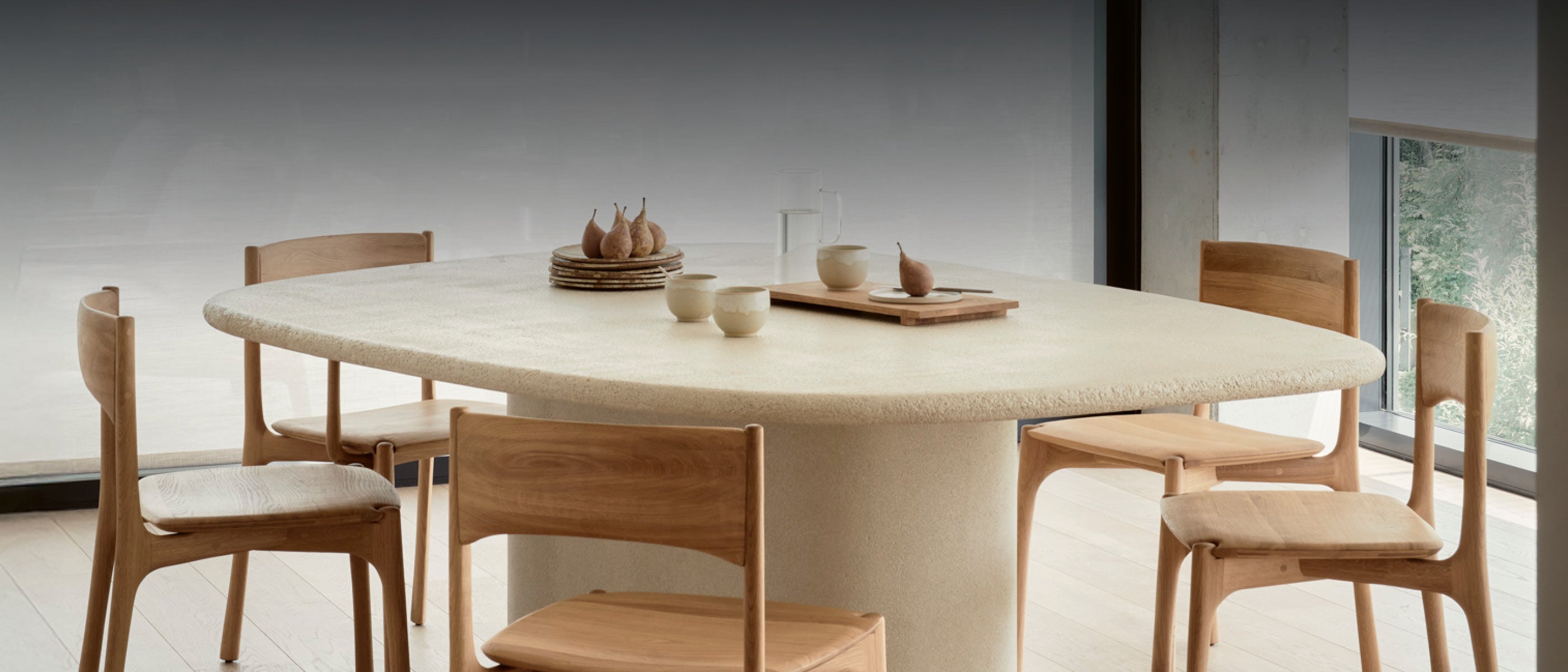 Organischer Esstisch aus Mikrozement mit Holzstühlen – Belgisches Design von Ethnicraft für Dining mit Nachhaltigkeit.