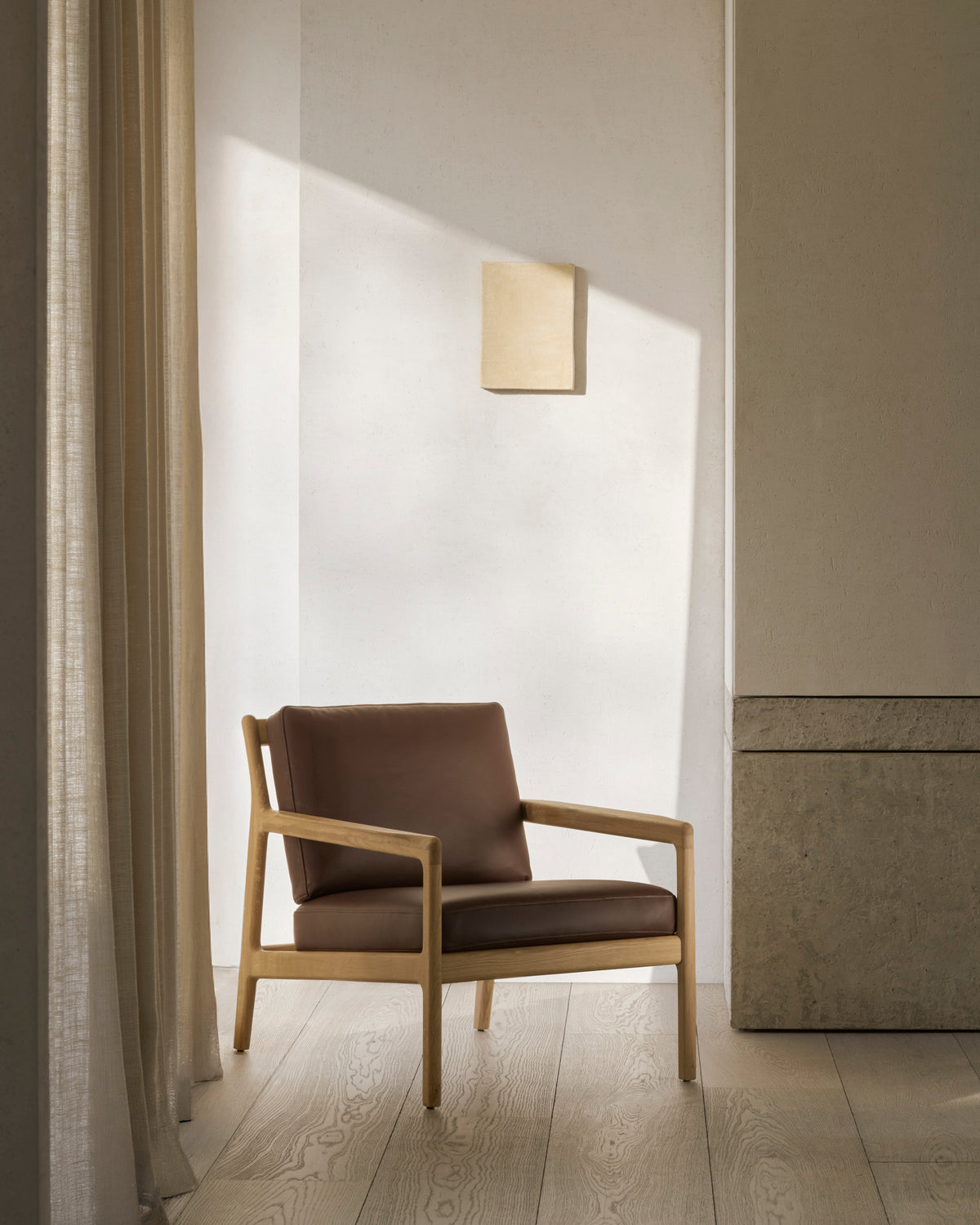 Ethnicraft JACK lounge chair made of solid oak with burgundy leather cushions and finely crafted wooden details.