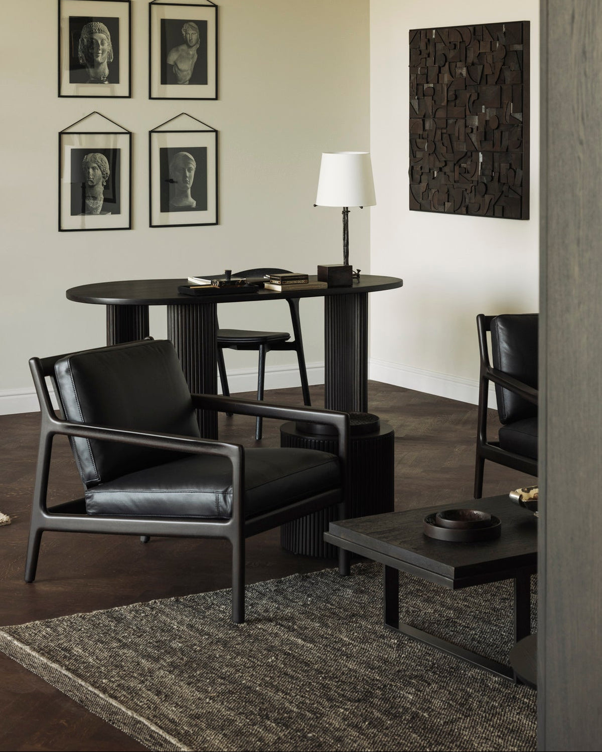 Ethnicraft JACK lounge chair in dark brown mahogany with Carbone leather cushions next to a side table in a reading nook.