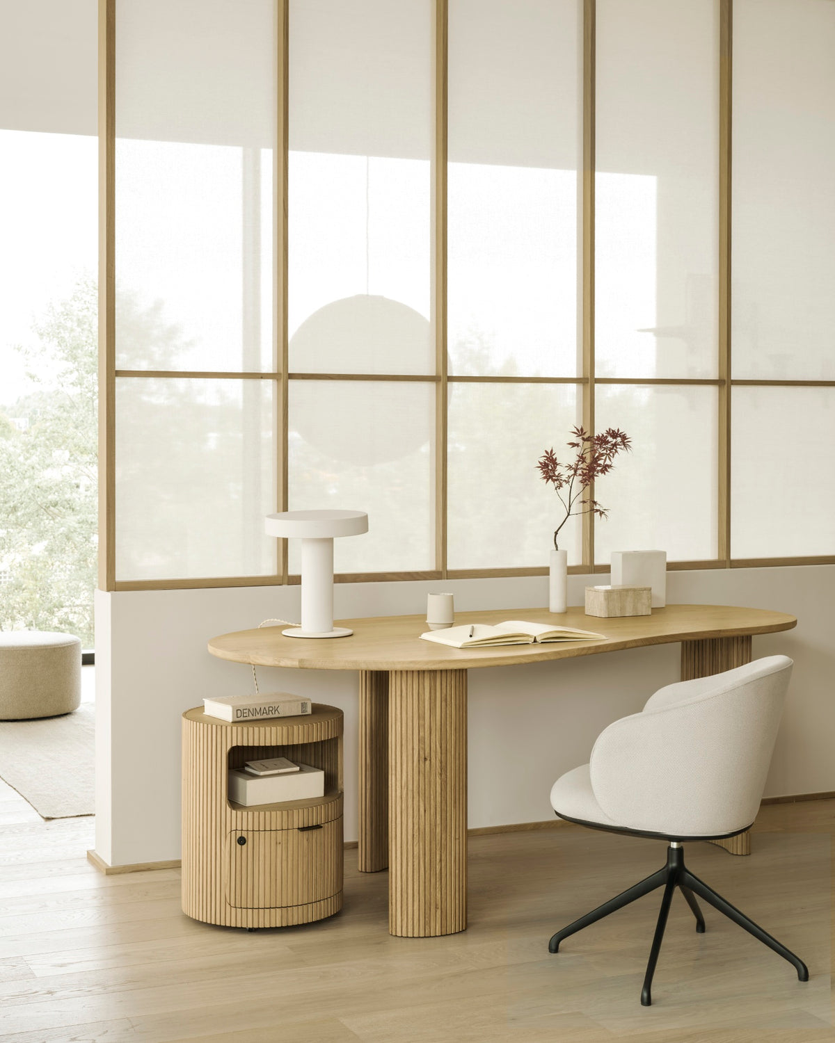 Chaise de bureau d'Ethnicraft UNDA, couleur Salt, équipée de roulettes, installée devant un bureau dans un espace de travail à domicile moderne.
