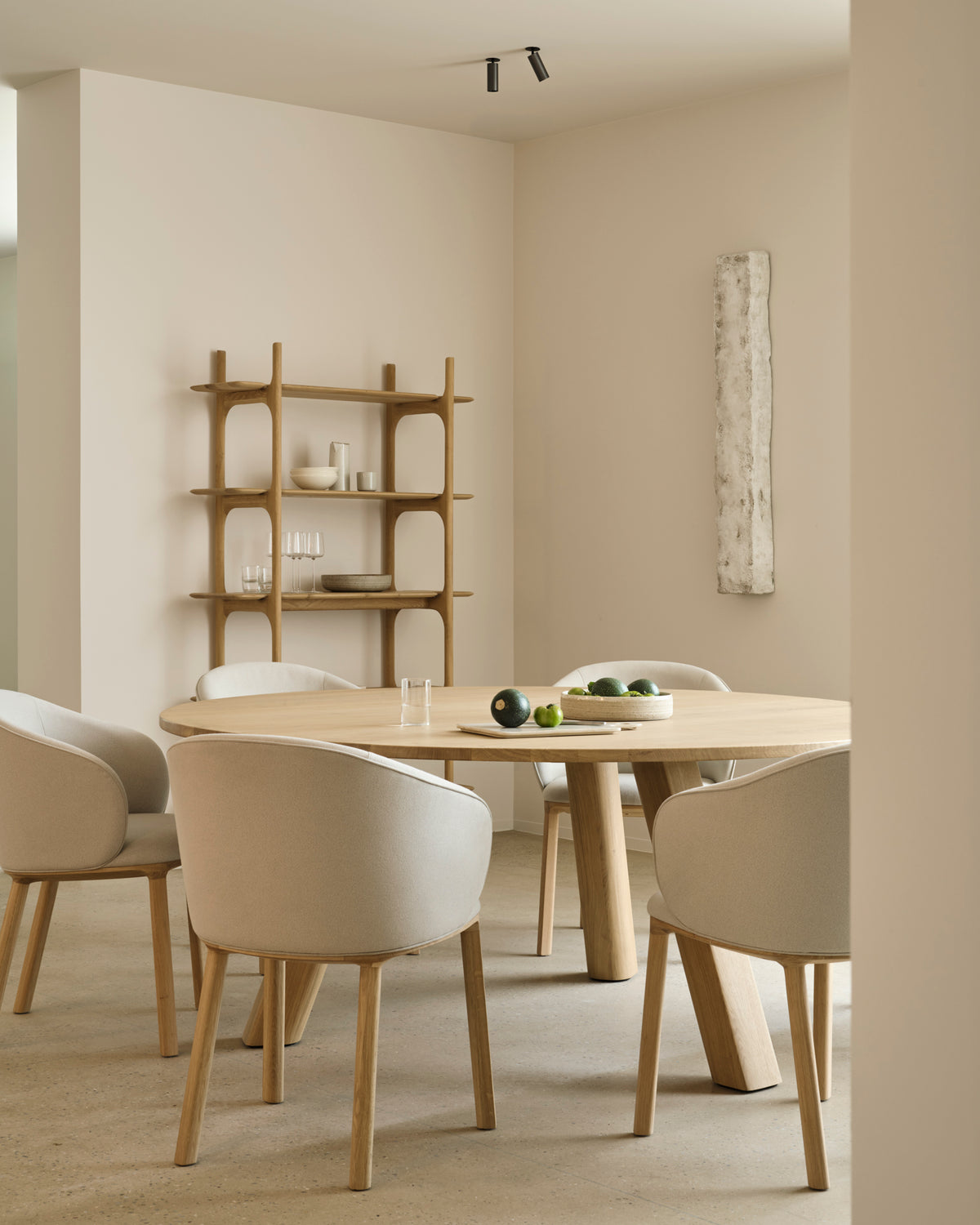 Ethnicraft UNDA dining table in natural oak with modern dining chairs in a bright dining area.