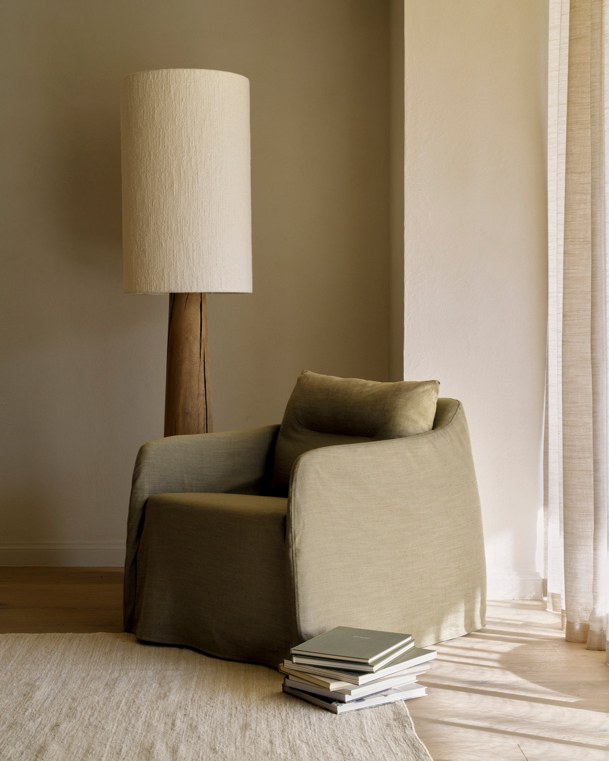 Ethnicraft WEAVE Loungesessel in Grün mit Drehgestell in einem modernen Wohnzimmer mit natürlichen Materialien.