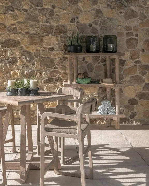 Gommaire Barstuhl SALLY im Outdoor-Lounge-Ambiente – kombiniert mit Stehtisch und grüner Bepflanzung für stilvolle Gartengestaltung mit Teakmöbeln