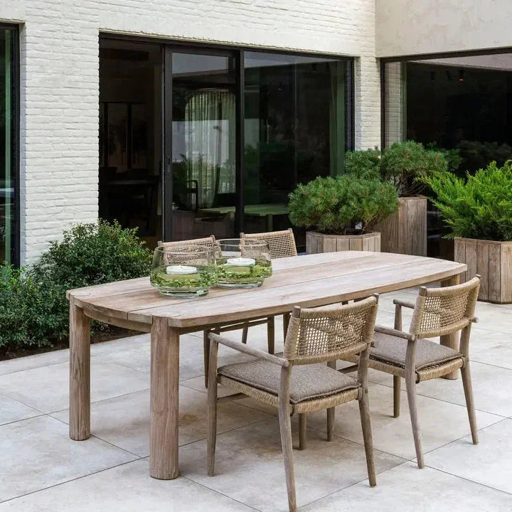 Outdoor-Szene mit Gommaire MIGUEL Gartentisch – stilvoll kombiniert mit Lounge-Stühlen auf einer Holzterrasse, perfekt für modernes Outdoor-Dining im Garten