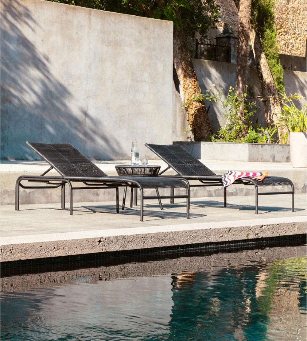 Bain de soleil LOOP de Vincent Sheppard, couleur noire, au bord de la piscine