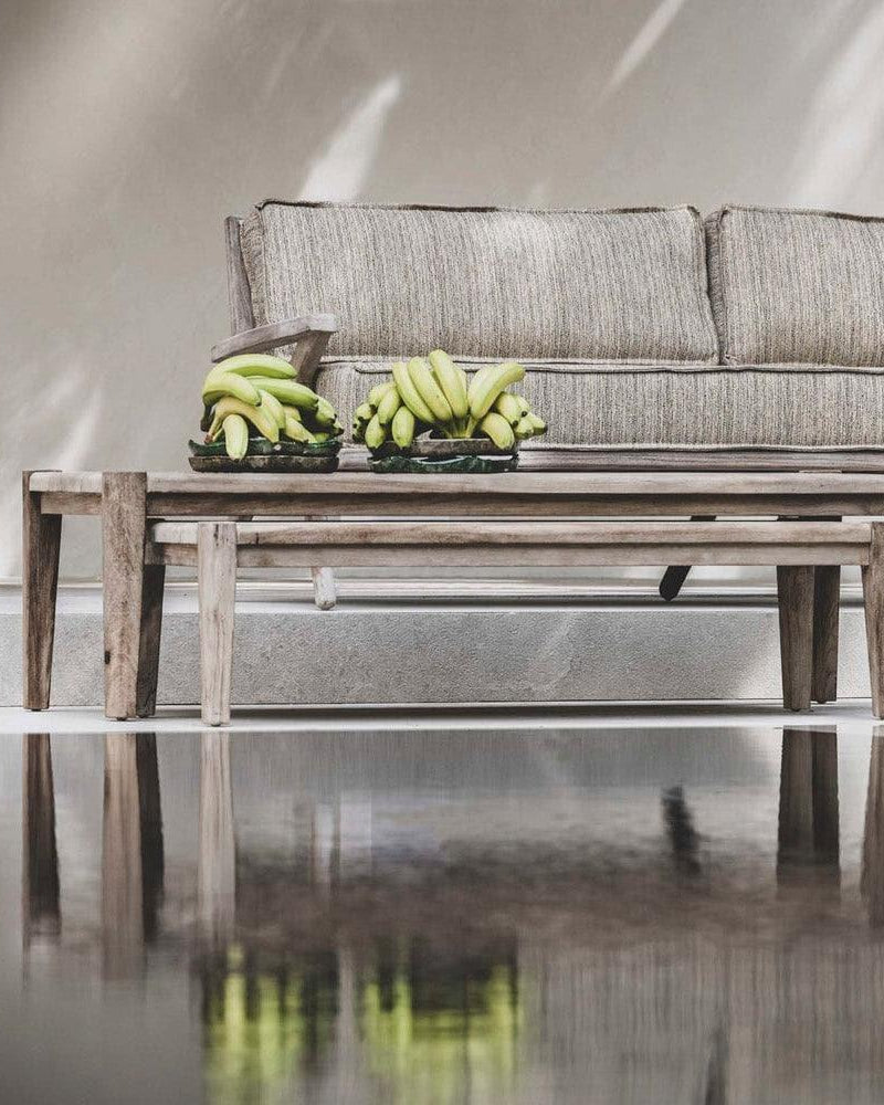 Couchtisch FLOOR von Gommaire in Kombination mit Lounge-Sofa – stilvolle Outdoor-Szene mit natürlichen Materialien und Teakmöbeln