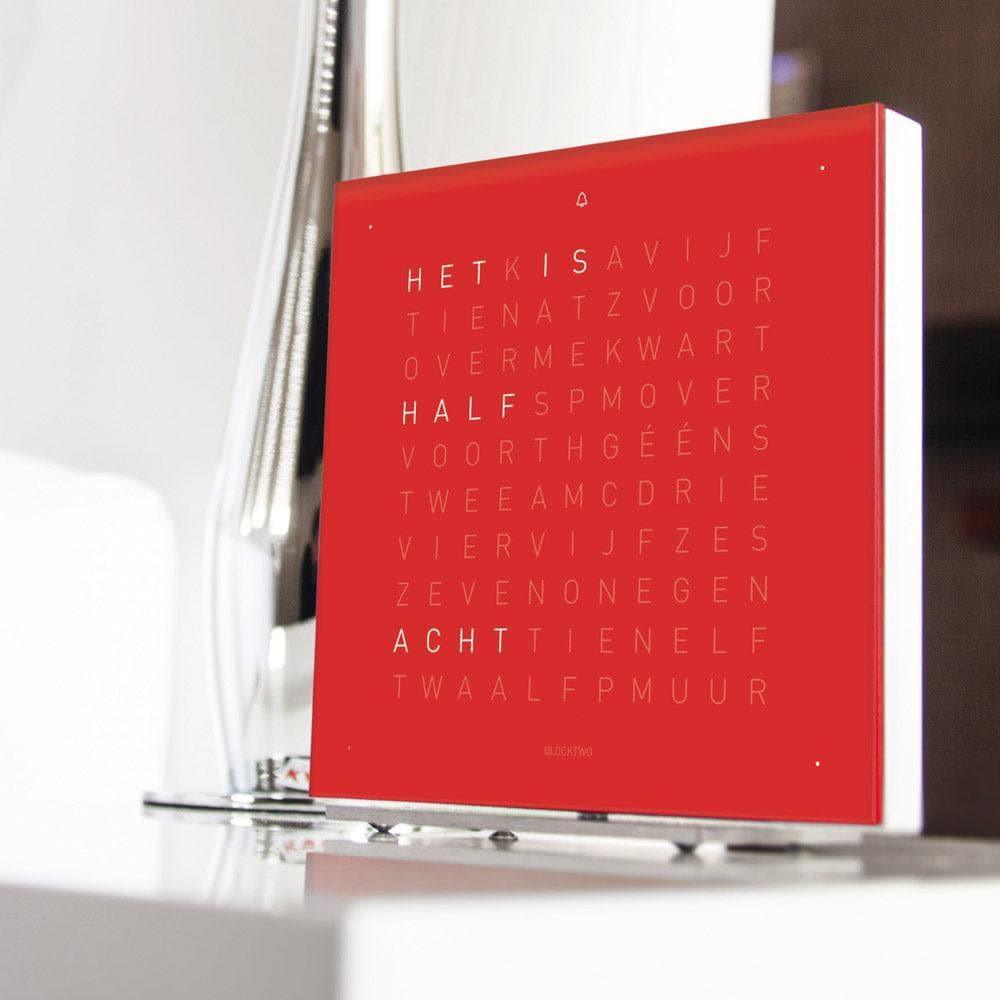 QLOCKTWO EARTH 13.5 Cherry Cake – moderne Design-Tischuhr mit typografischer Zeitanzeige in tiefem Rot, stilvoll inszeniert im Raum auf Sideboard oder Regal