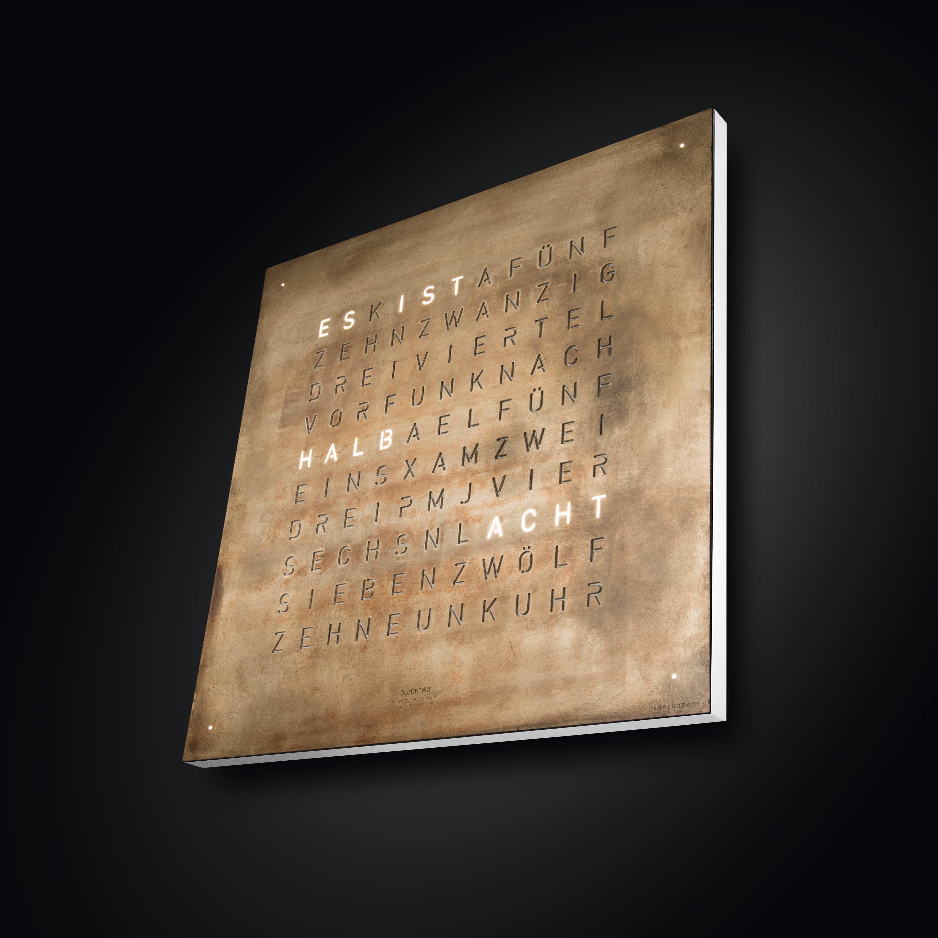 QLOCKTWO EARTH 45 Silver & Gold – kunstvolle Designuhr mit glanzvoller Metalloberfläche, stilvoll inszeniert im modernen Wohnambiente