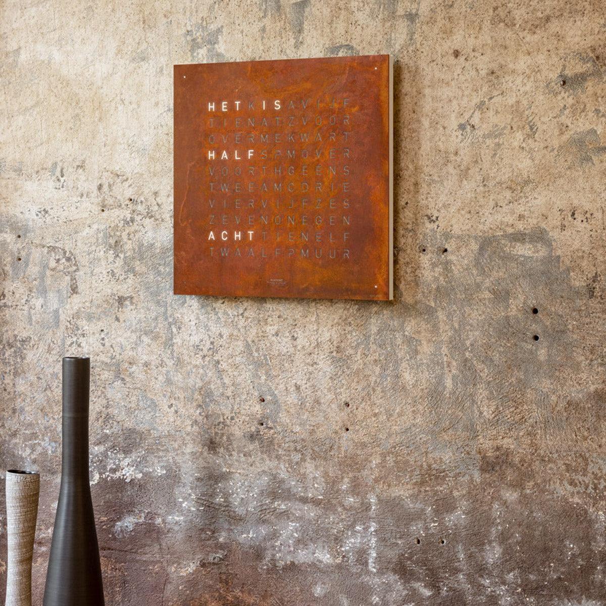 QLOCKTWO EARTH 45 Rust – vooraanzicht van de exclusieve roestkleurige wandklok uit de Creator’s Edition met unieke staalpatina
