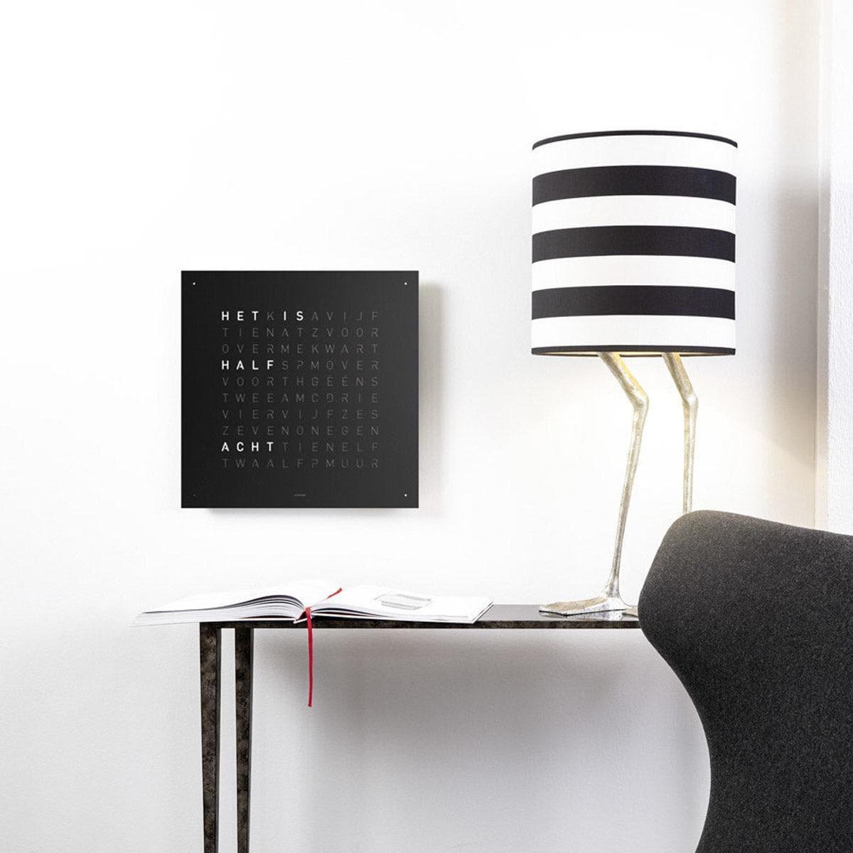 QLOCKTWO EARTH 45 Black Pepper – vooraanzicht van de wandklok in diepzwart staal met typografische tijdweergave, Steel Series