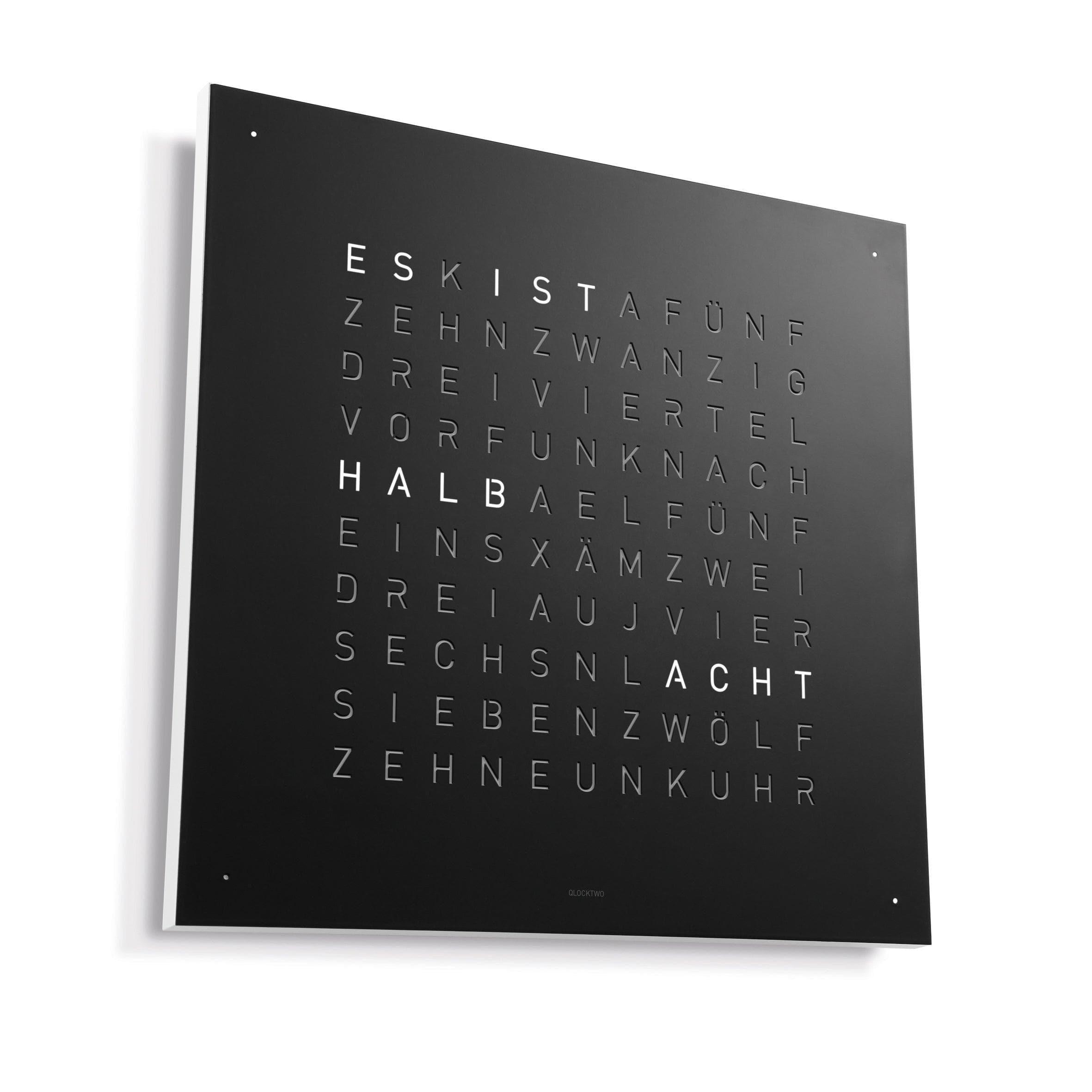QLOCKTWO EARTH 90 mit weißem Korpus – klare Formensprache trifft auf schwarze Stahloberfläche in exklusivem Design